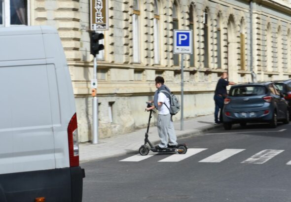 Gyalogátkelőhelyen keresztül száguld az elektromos rollerrel a fiatal védőfelszerelés nélkül Fotó: Benedek Bálint